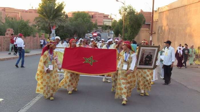 Carnaval d'ouverture : troupe portant le drapeau marocain et un portrait royal dans les rues de Ouarzazate, 12 mai 2023.